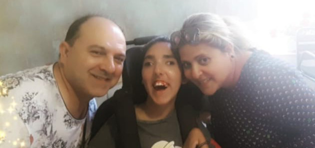 Carla, con parálisis cerebral infantil, junto a su madre y su padre